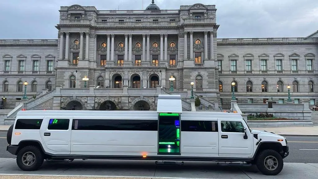 White Hummer stretch limousine with its door open and cabin glowing at the Library of Congress, ready for a Washington DC night tour