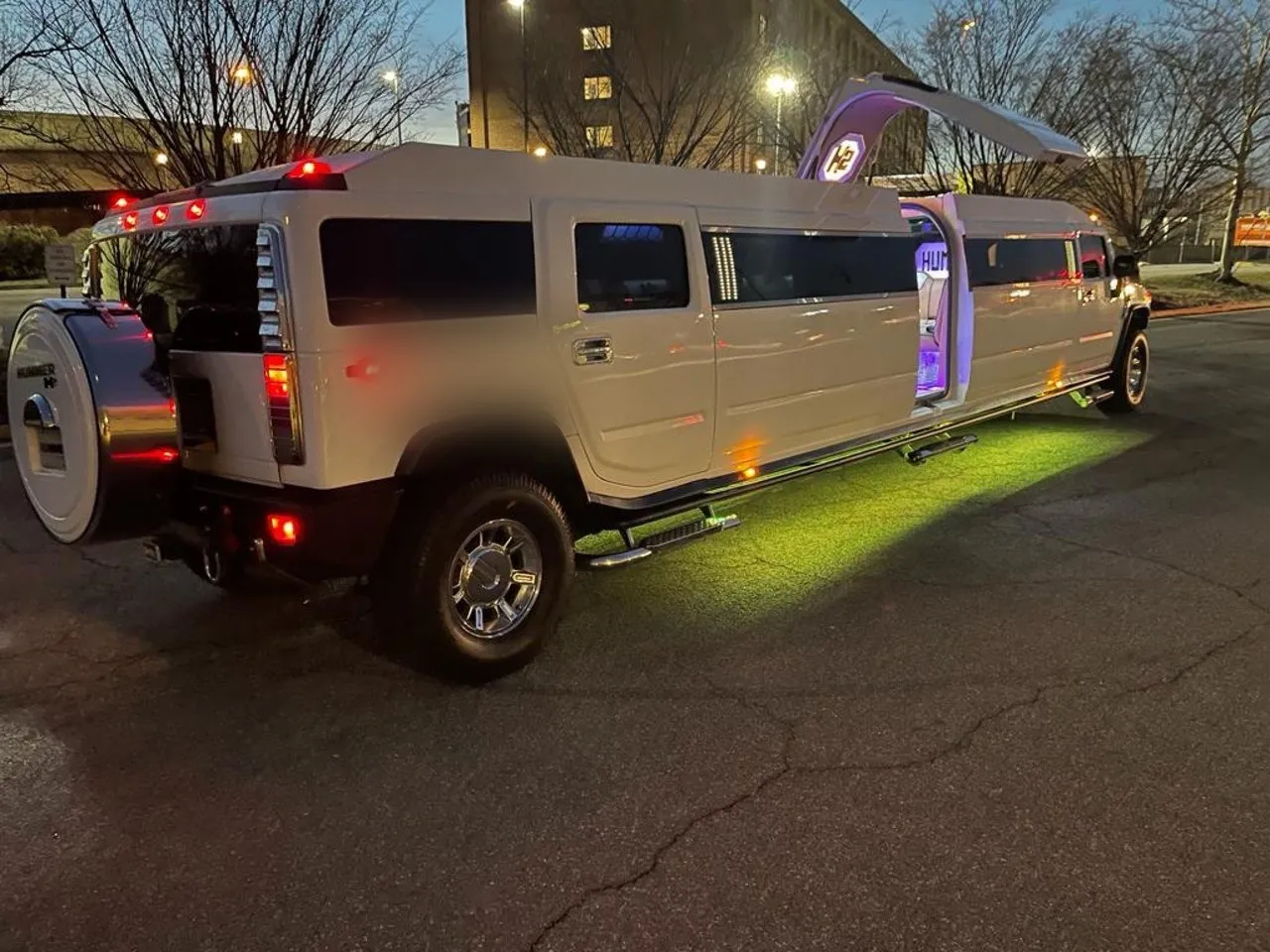White Hummer stretch limousine with LED underglow and door open at night, Smart Limo Rental Washington DC fleet