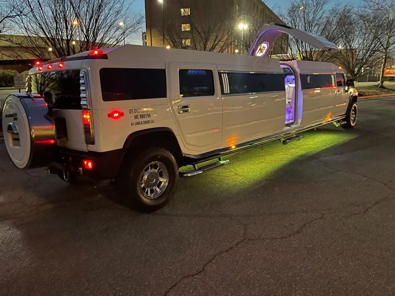 White Hummer stretch limo at night with open door and LED underglow, Smart Limo Rental DC
