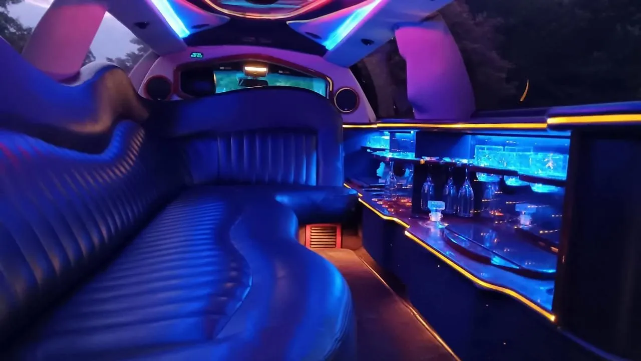 Stretch limo interior with wrap-around leather seating and lit glassware bar, Smart Limo Rental DC